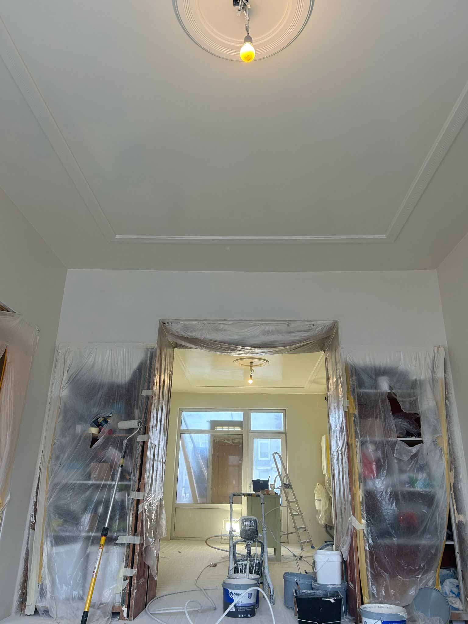 Woning hoge plafonds volledig afgeplakt en voorzien van latex spuitwerk.